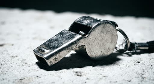 Metallic whistle under harsh light — pitch tension